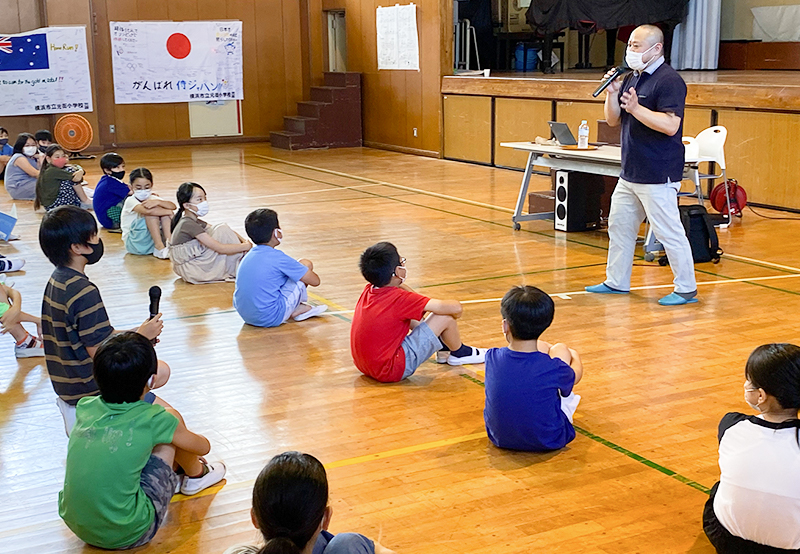 横浜市立元街小学校の体育館で、子供達に向けて話す初瀬の画像